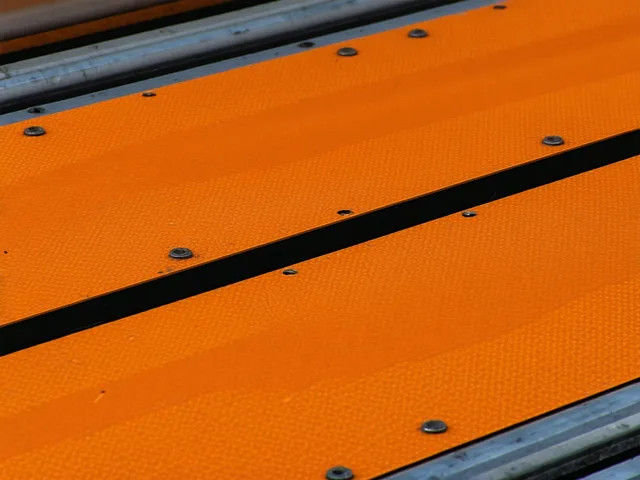 Close-up of stamped metal automotive part being inspected on an industrial conveyor line